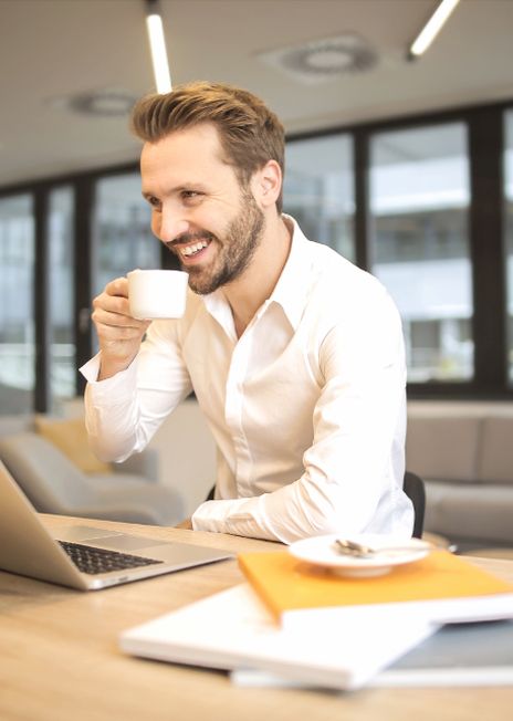 Business owner having a coffee at his laptop